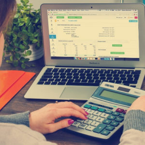 woman using laptop with charts and calculator