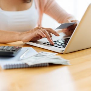 woman using credit card to pay online laptop